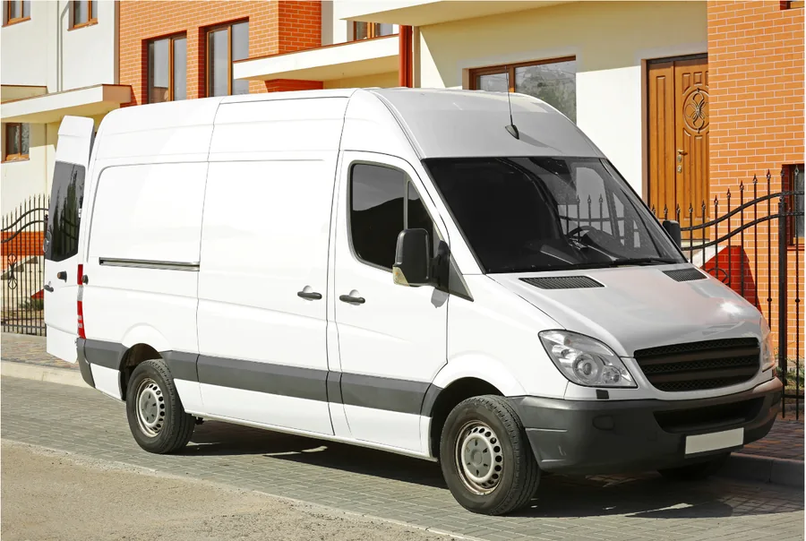 White van, ready to leave, parked at the kerb outside a block of flats